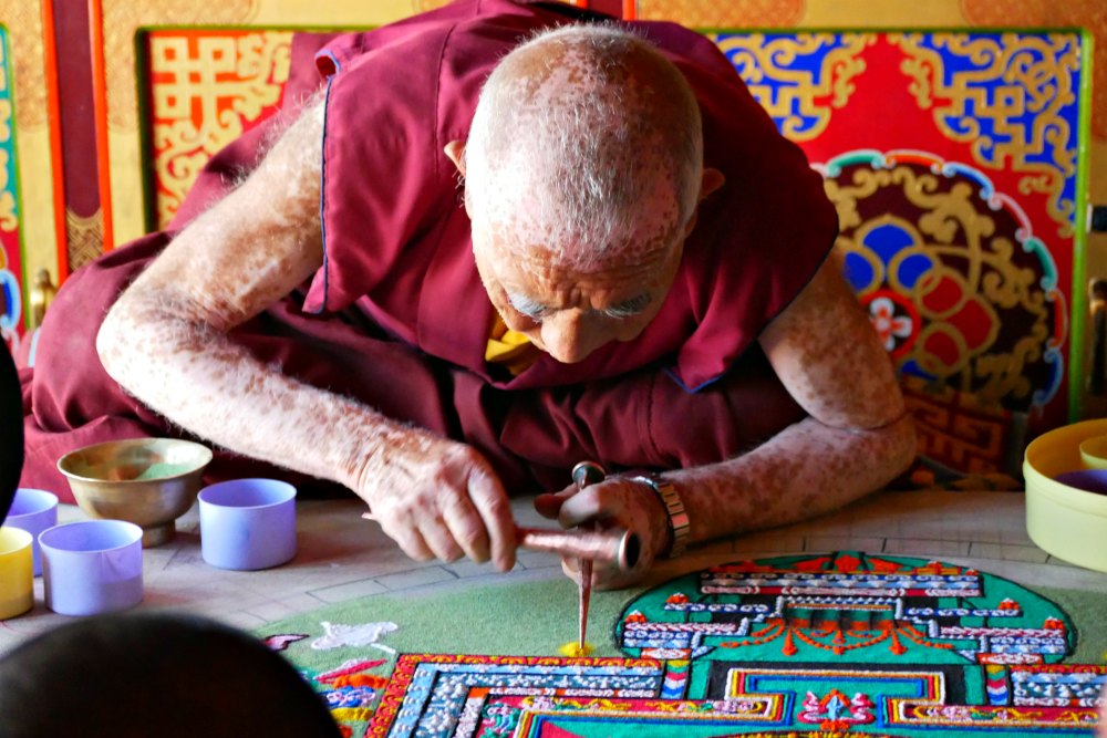 Mönch beim Erstellen eines Sand-Mandalas
